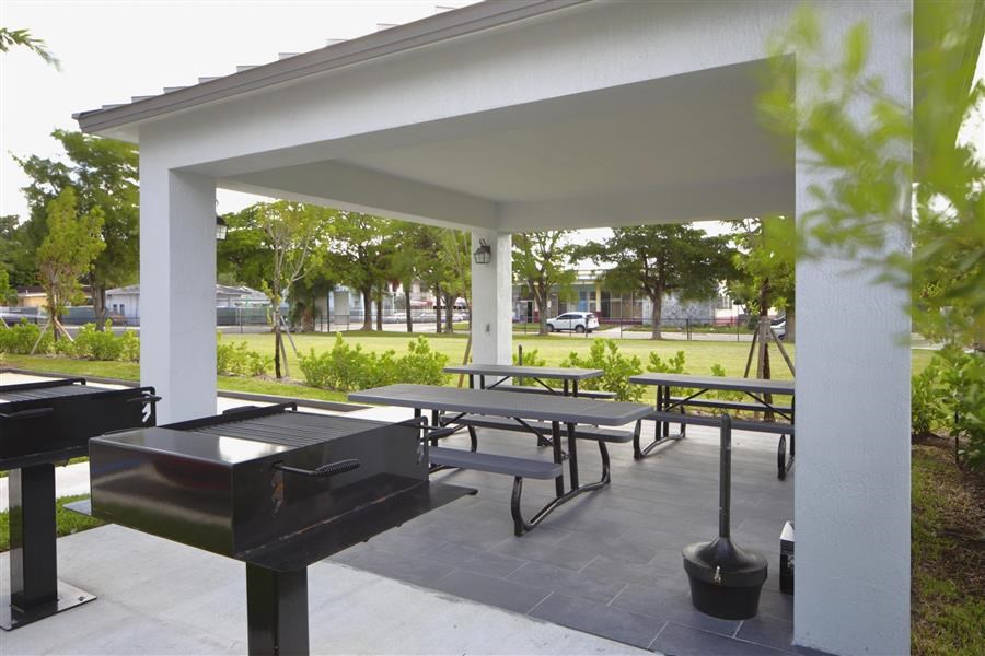 a picnic area with benches and tables and a grill