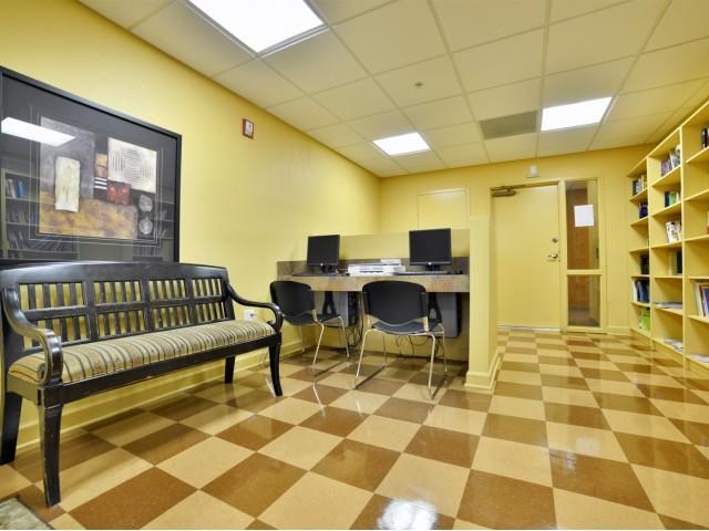 a library with a computer desk and a bench
