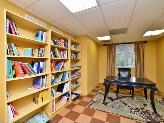 a library with a piano and a table