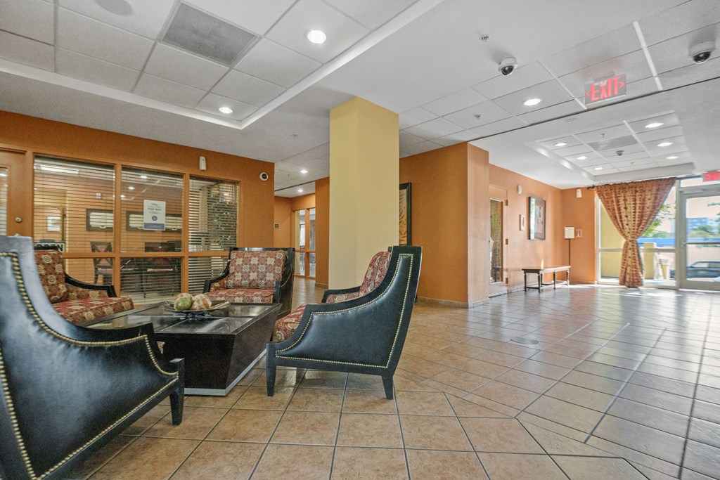 the lobby of a hotel with chairs and a table