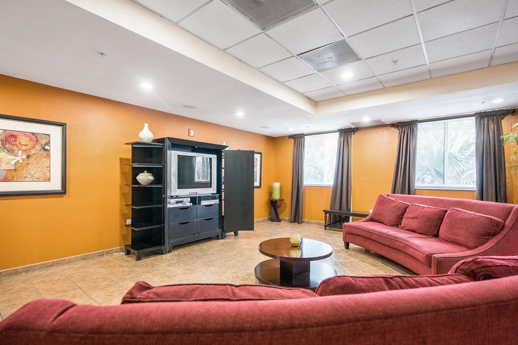 a living room with red couches and a television