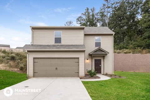 a beige house with a driveway and a garage door