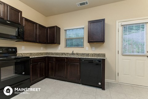 a kitchen with dark wood cabinets and granite counter tops and black appliances