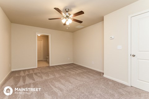 the spacious living room with carpeting and a ceiling fan
