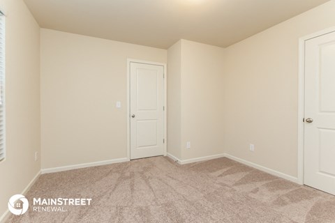 the upstairs bedroom has a carpeted floor and two closets