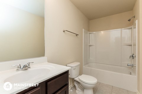 a bathroom with a shower toilet and sink and a mirror