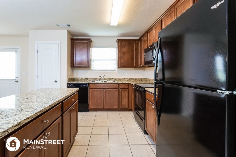a kitchen with wooden cabinets and black appliances