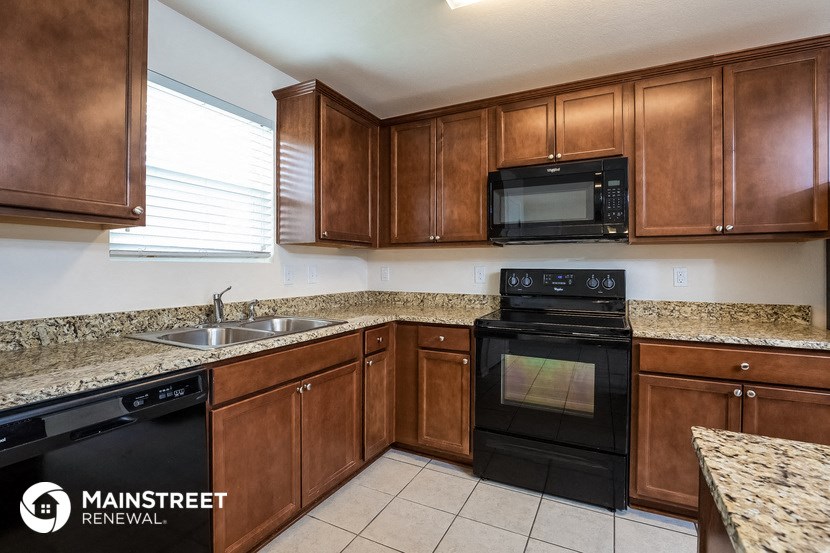 a kitchen with wooden cabinets and black appliances and granite counter tops