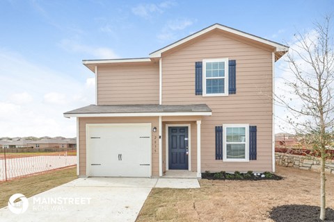 a tan house with blue shutters and a white garage door