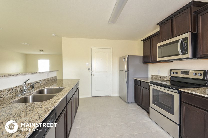 a kitchen with granite counter tops and stainless steel appliances and wooden cabinets