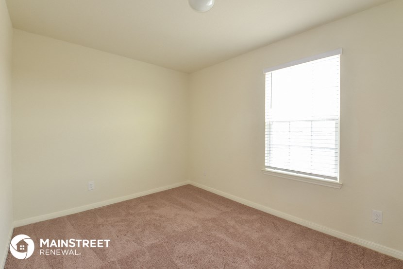 the upstairs bedroom with carpet and a window