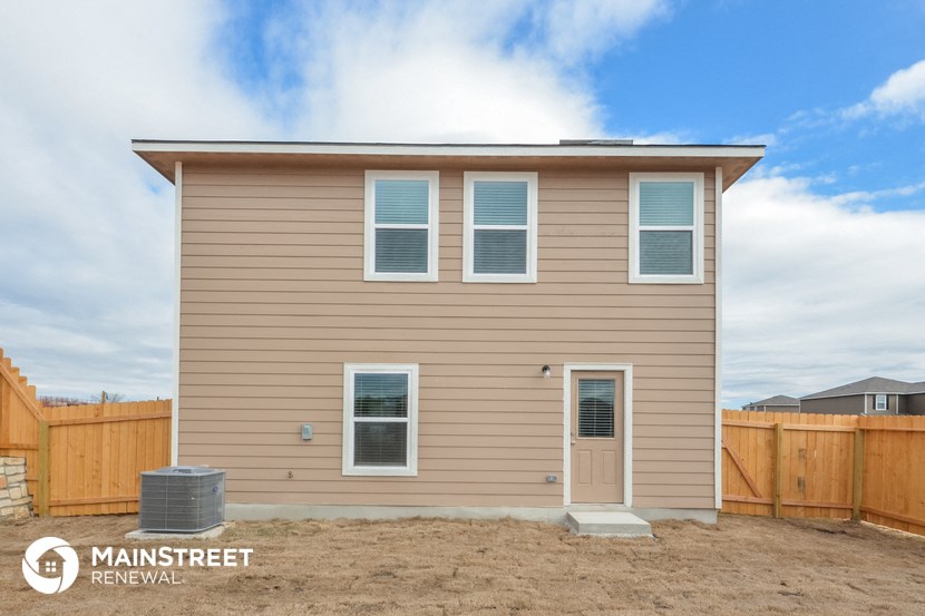 a craftsman style home with tan siding and a wooden fence