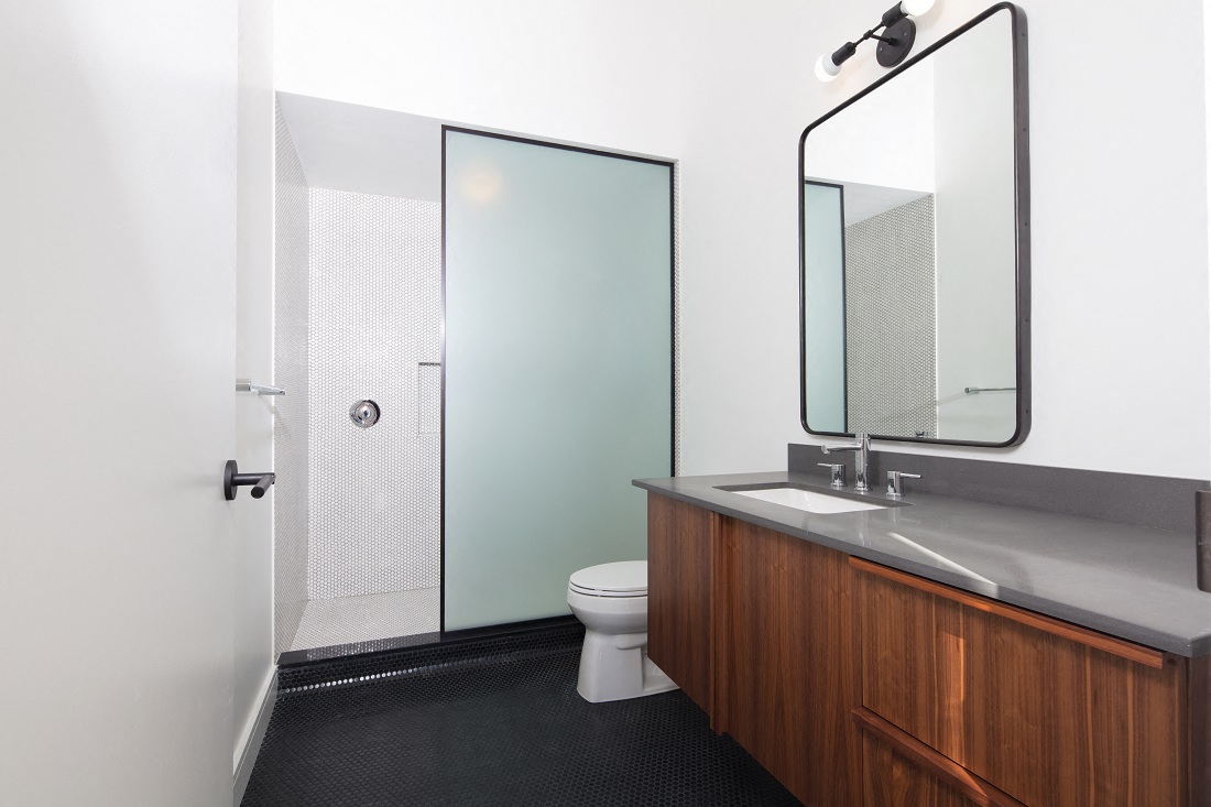 a bathroom with a shower and a sink and a mirror