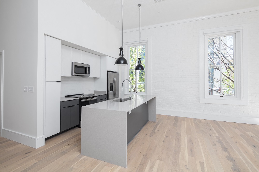 the kitchen has a large island and black and white appliances