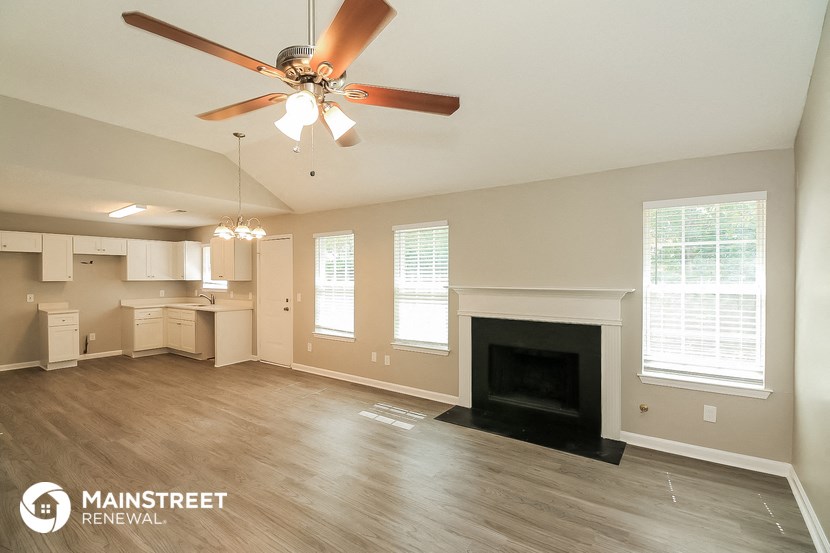 a living room with a ceiling fan and a fireplace