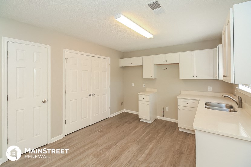a kitchen with white cabinets and a sink and a white counter top