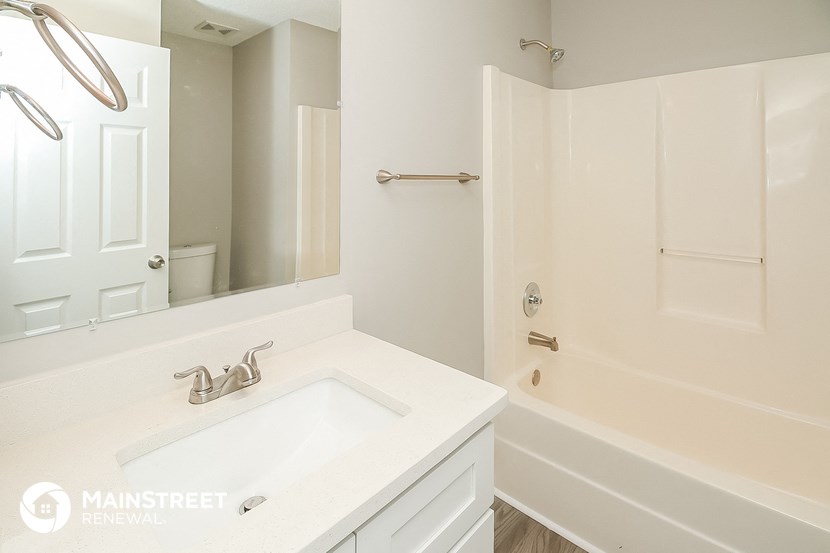 a bathroom with a sink and a tub and a mirror