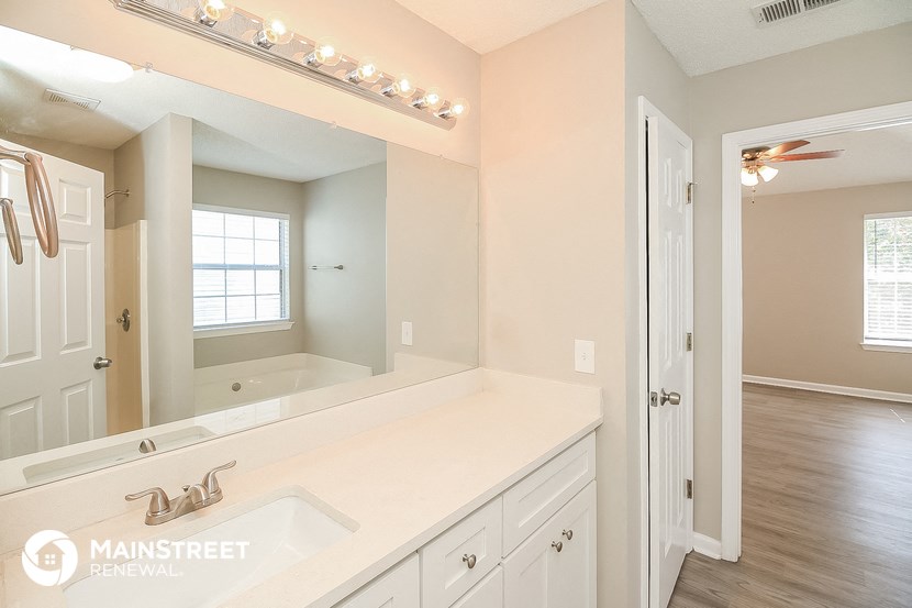 the master bathroom has a large mirror and a large sink