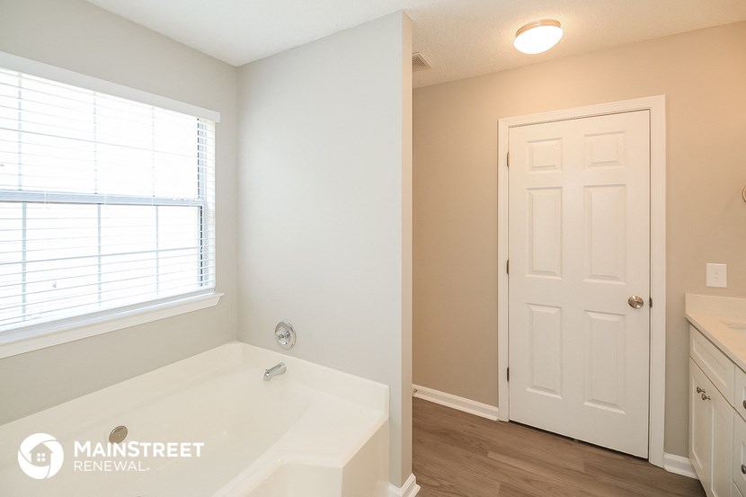 a bathroom with a large tub and a white door