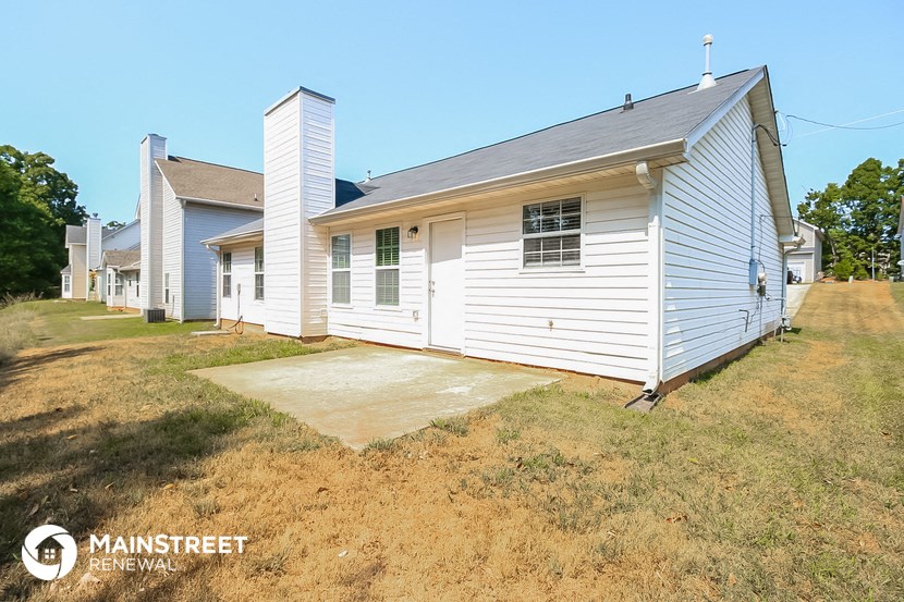 a small white house with a yard in front of it