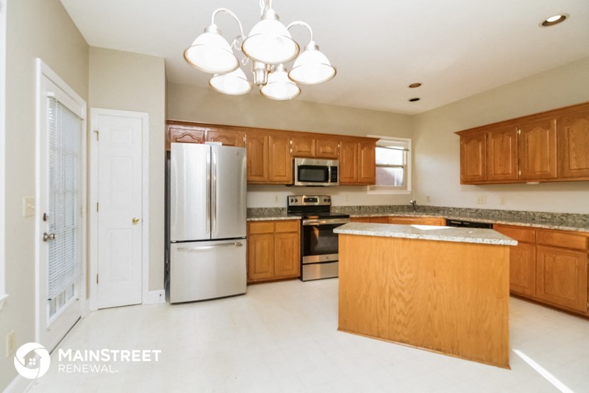 a large kitchen with wooden cabinets and stainless steel appliances