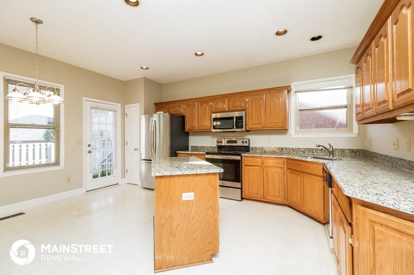 a kitchen with wooden cabinets and granite counter tops and a sink