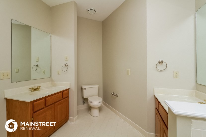 a bathroom with a toilet sink and mirror and a tub