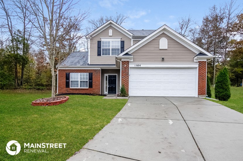 the front of a house with a concrete driveway