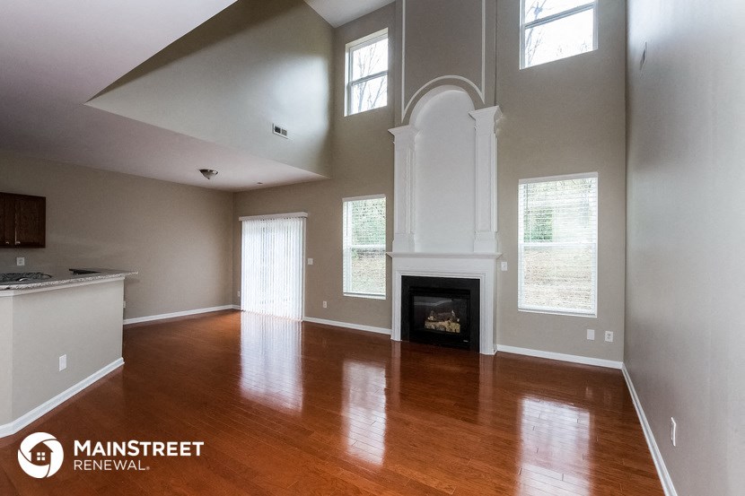 a living room with wood floors and a fireplace