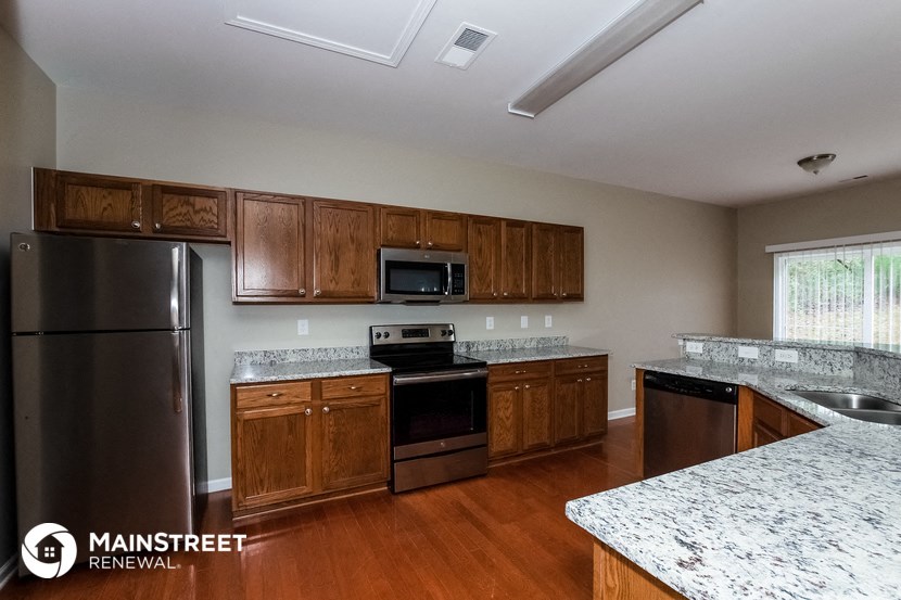 a kitchen with wooden cabinets and stainless steel appliances