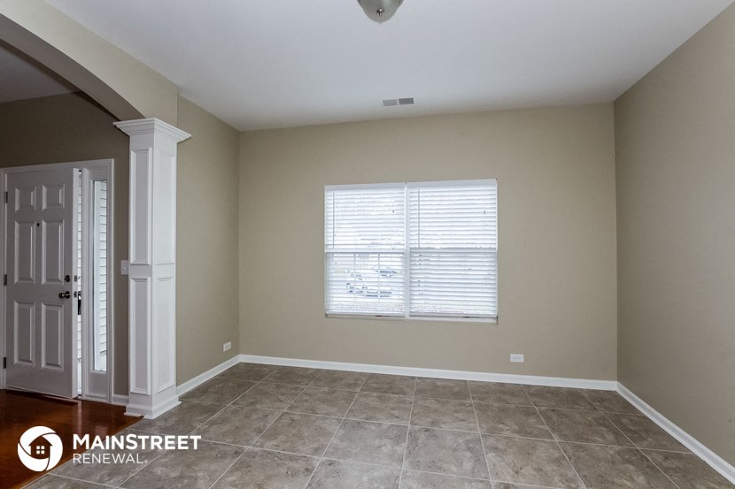 the master bedroom has a large window and tile floor