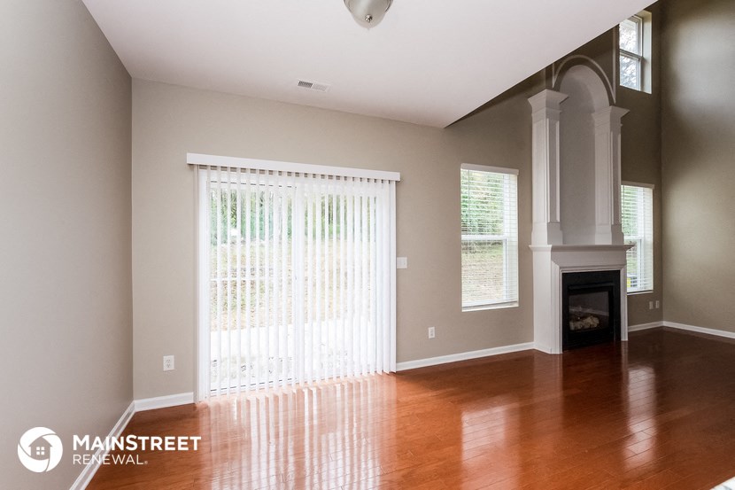 a living room with wood floors and a fireplace