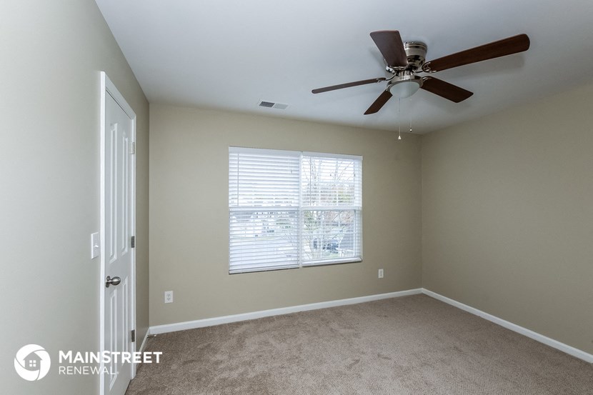 a bedroom with a ceiling fan and a window