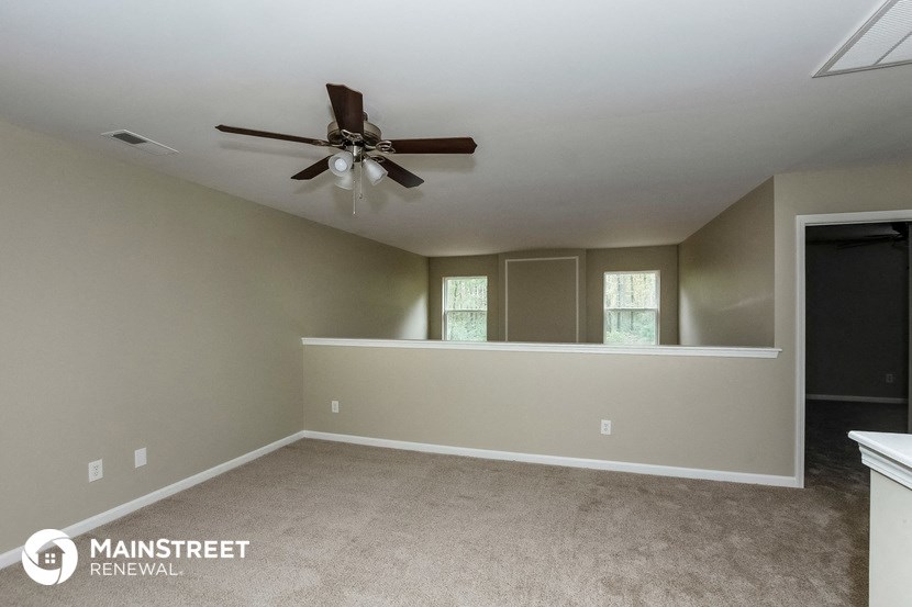 a room with carpet and a ceiling fan