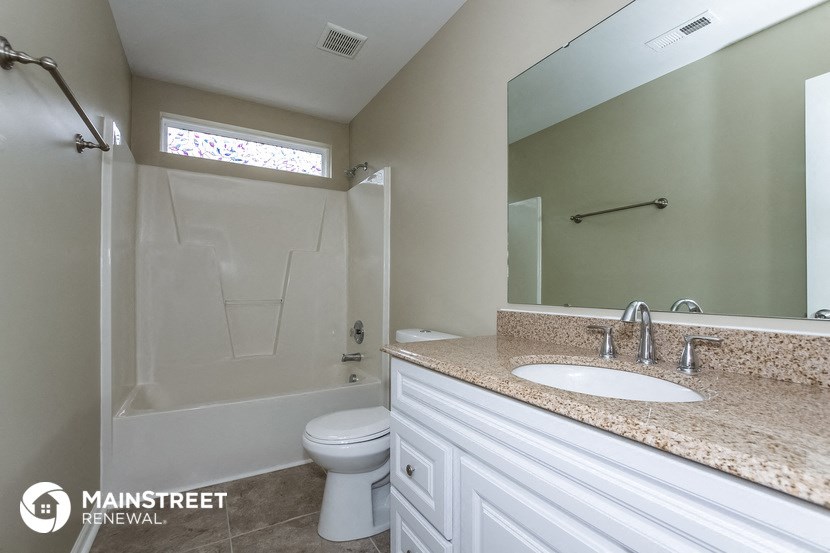 a bathroom with a shower toilet and sink and a mirror
