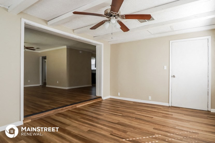 the living room of an empty house with wood floors and a ceiling fan