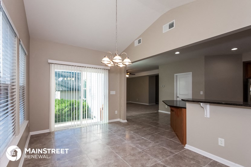 a kitchen and living room with a sliding glass door to a patio