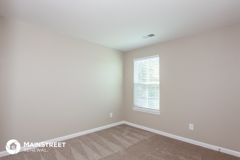 the upstairs bedroom with carpet and window