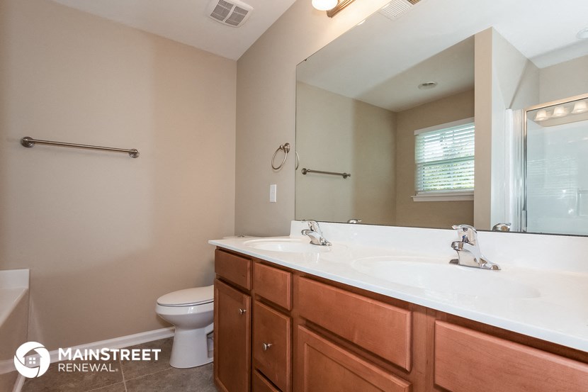 a bathroom with a sink toilet and a mirror