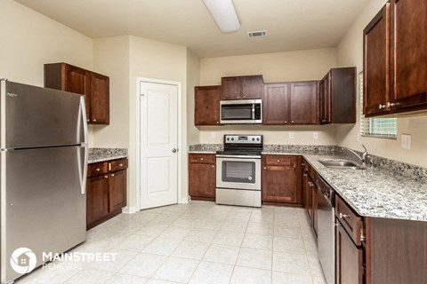 a kitchen with wooden cabinets and granite counter tops and stainless steel appliances