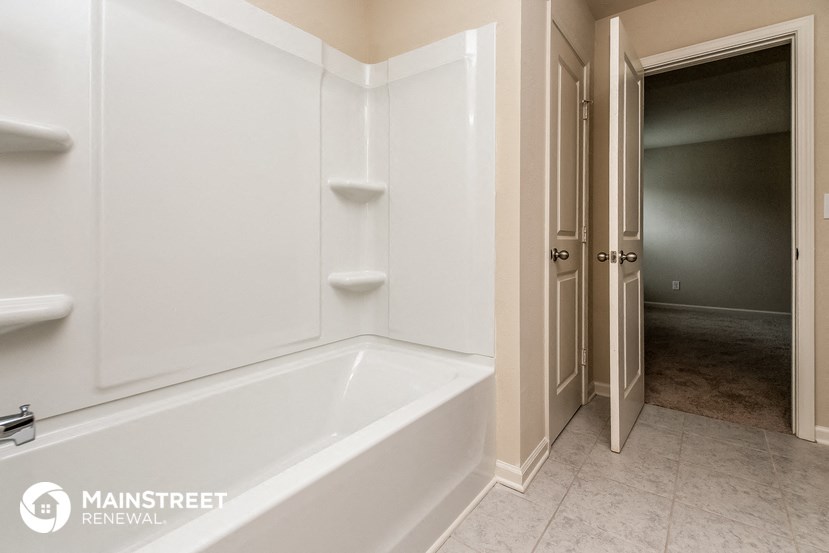 a bathroom with a bath tub and a closet