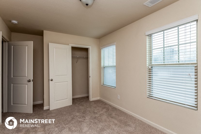 the interior of a bedroom with a closet and a window
