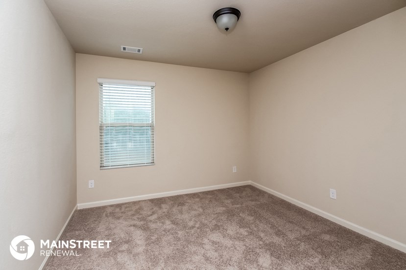 the upstairs bedroom with carpeted flooring and a window