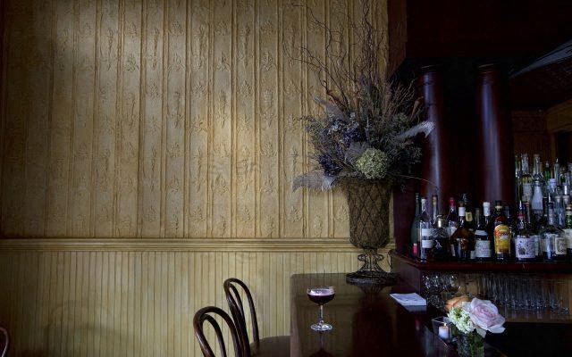 a table with chairs and a vase with flowers