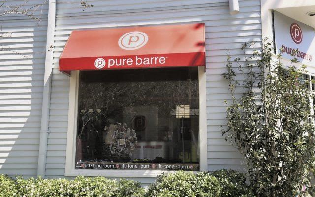a pure barre store window with a red sign