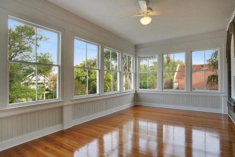 a living room with a wood floor and large windows