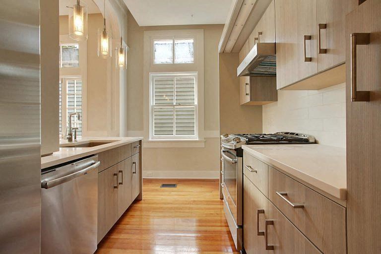 a kitchen with stainless steel appliances and wooden floors