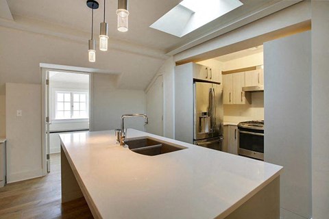 a kitchen with a white counter top and a sink