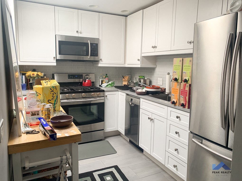 a kitchen with white cabinets and stainless steel appliances