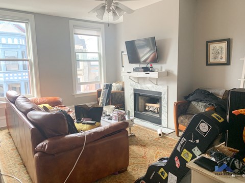 a living room with couches and a fireplace and a tv